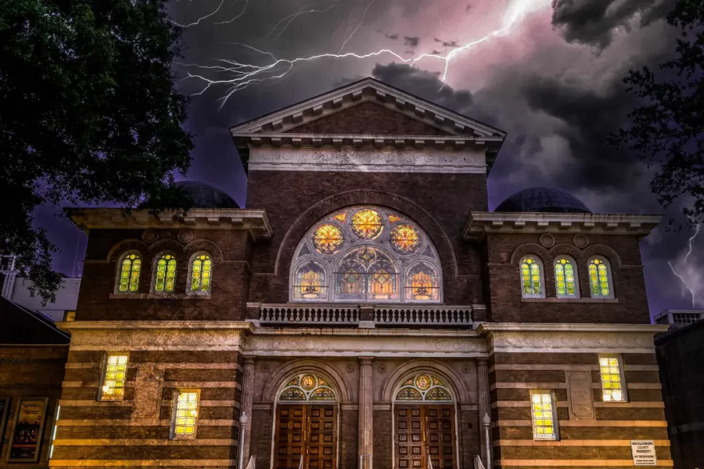 A creepy building with lighting over it